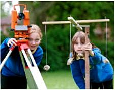 Contrasting surveying technology....the digital theodolite bought with a grant from the L.H.I. and the groma that the children helped to make.   Photo by Tony Jedrej, Countryside Commission.